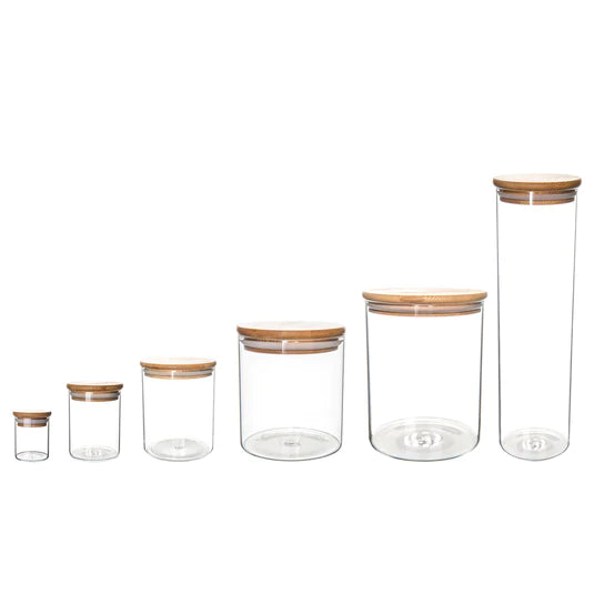 Six glass storage containers arranged from smallest to largest displayed on a white background