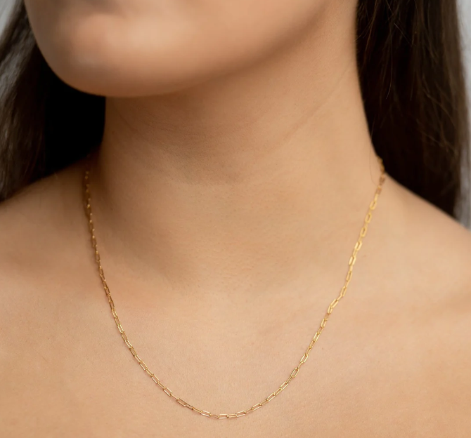 Gold vermeil paperclip necklace worn around the neck of someone close up