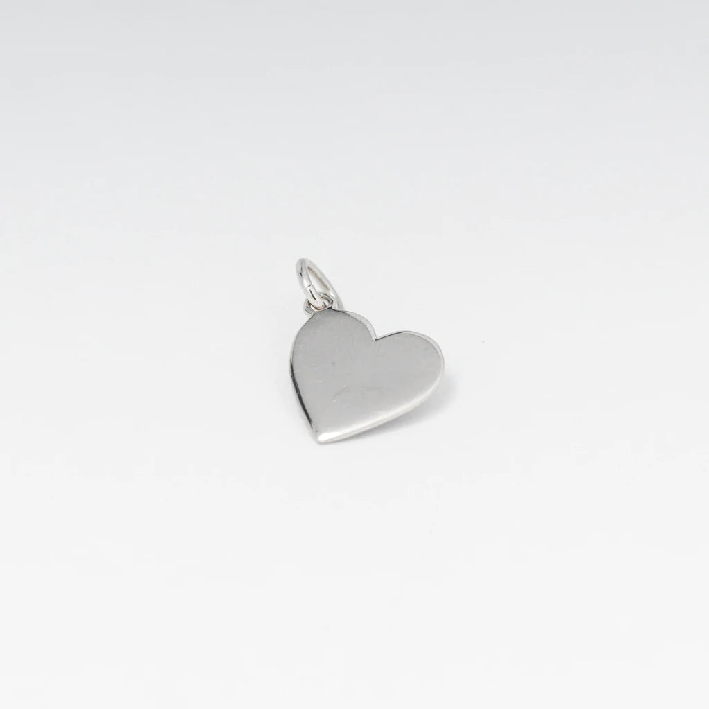 Silver heart charm pendant displayed on white background, close up